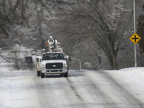 Utility truck driving on a snow-covered road. 