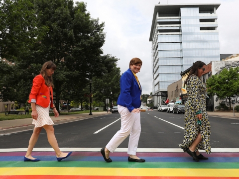 three women crossing a rainbow colored crosswalk in downtown Lexington