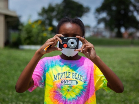 Student holding a camera to take a photo