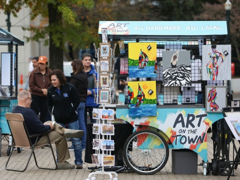 Art on the Town carts cover in art with people admiring the art.