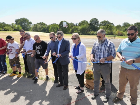 People cutting a ribbon at the basketball court at Berry Hill Park