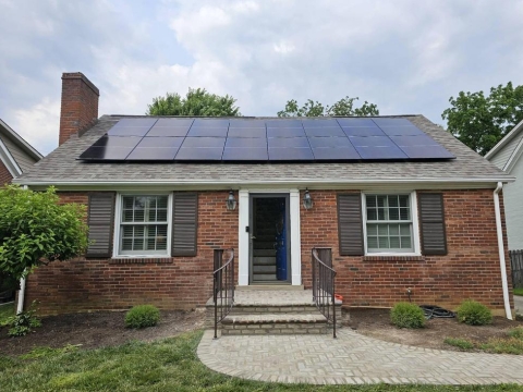 brick home with solar panels on the roof